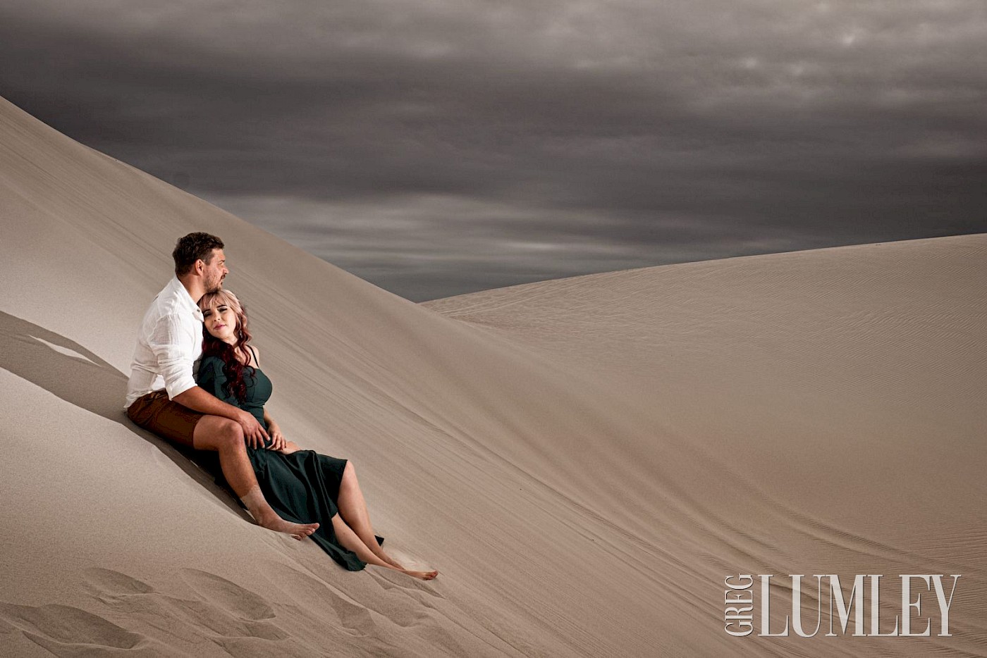 Newly engaged couple sitting on the Dunes of Atlantis in the Western Cape