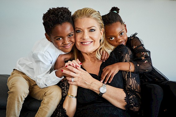 A beautiful mother and her two young children posing for a family photo at her 50th birthday.