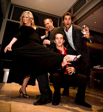 A lively group of well-dressed boys and a beautiful blonde woman dancing and having fun at a 30th birthday party